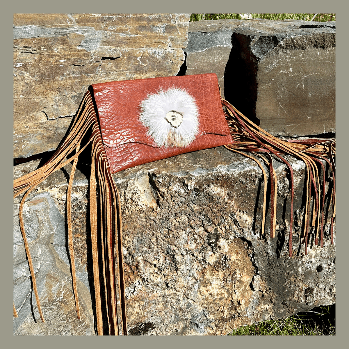 Bridger Leather Bangtail Clutch is made with bison leather, white arctic fox and handcuff 18" fringe.