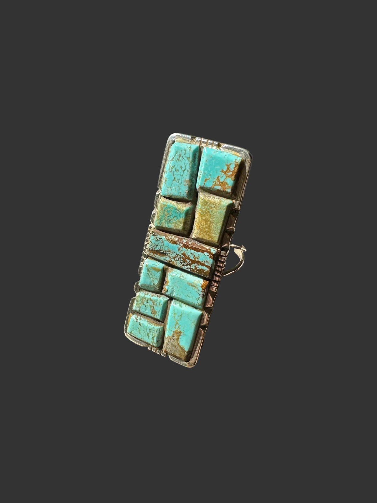 Front view of the long rectangular Brandon Etsitty Navajo ring with individually cut turquoise stones in blue, aqua and green, set in sterling silver