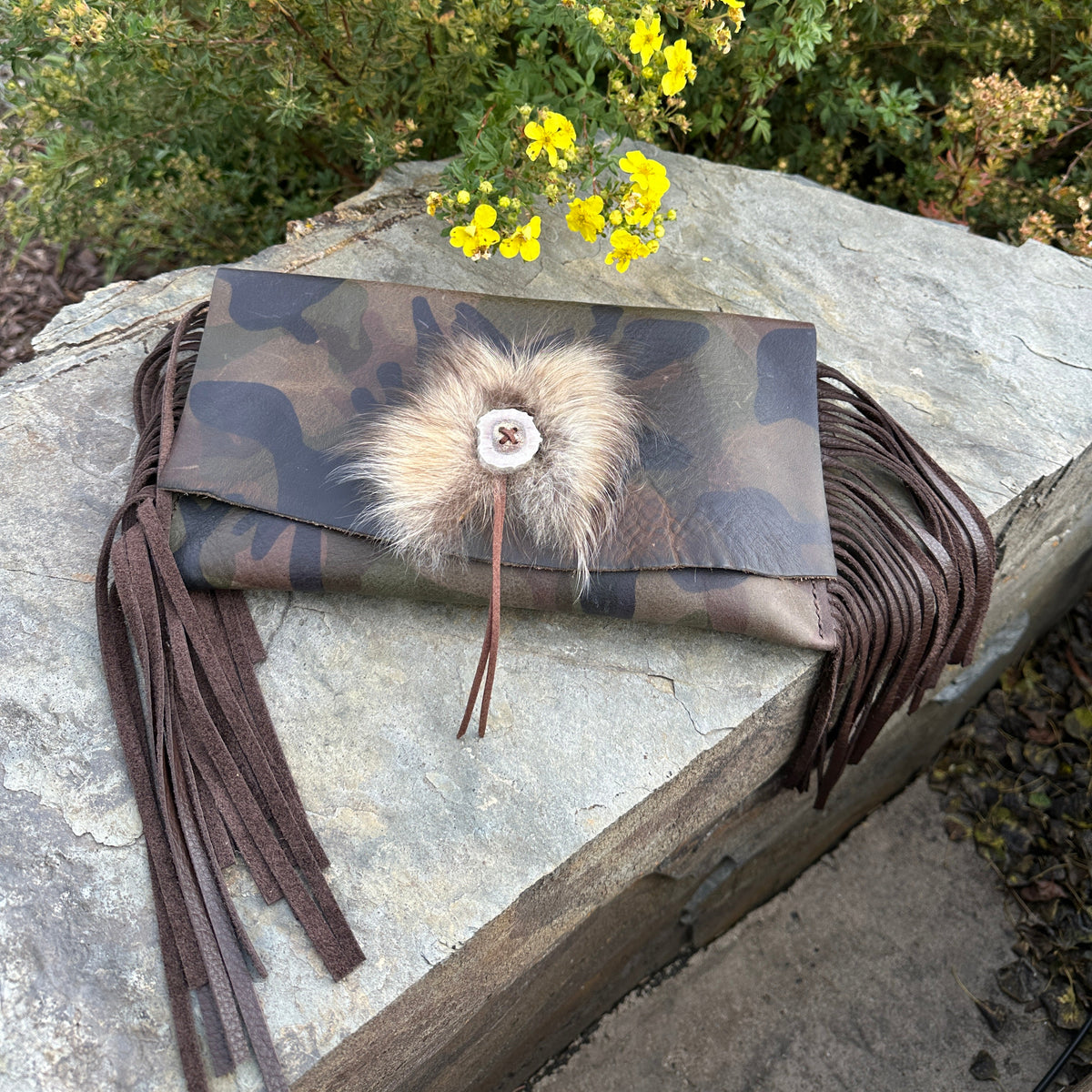 Upland Camo Leather Clutch by Bridger Leather — camo-printed Italian leather fold-over clutch with leather fringe, an antler button, and a Finn raccoon fur accent, handmade in Bozeman, Montana