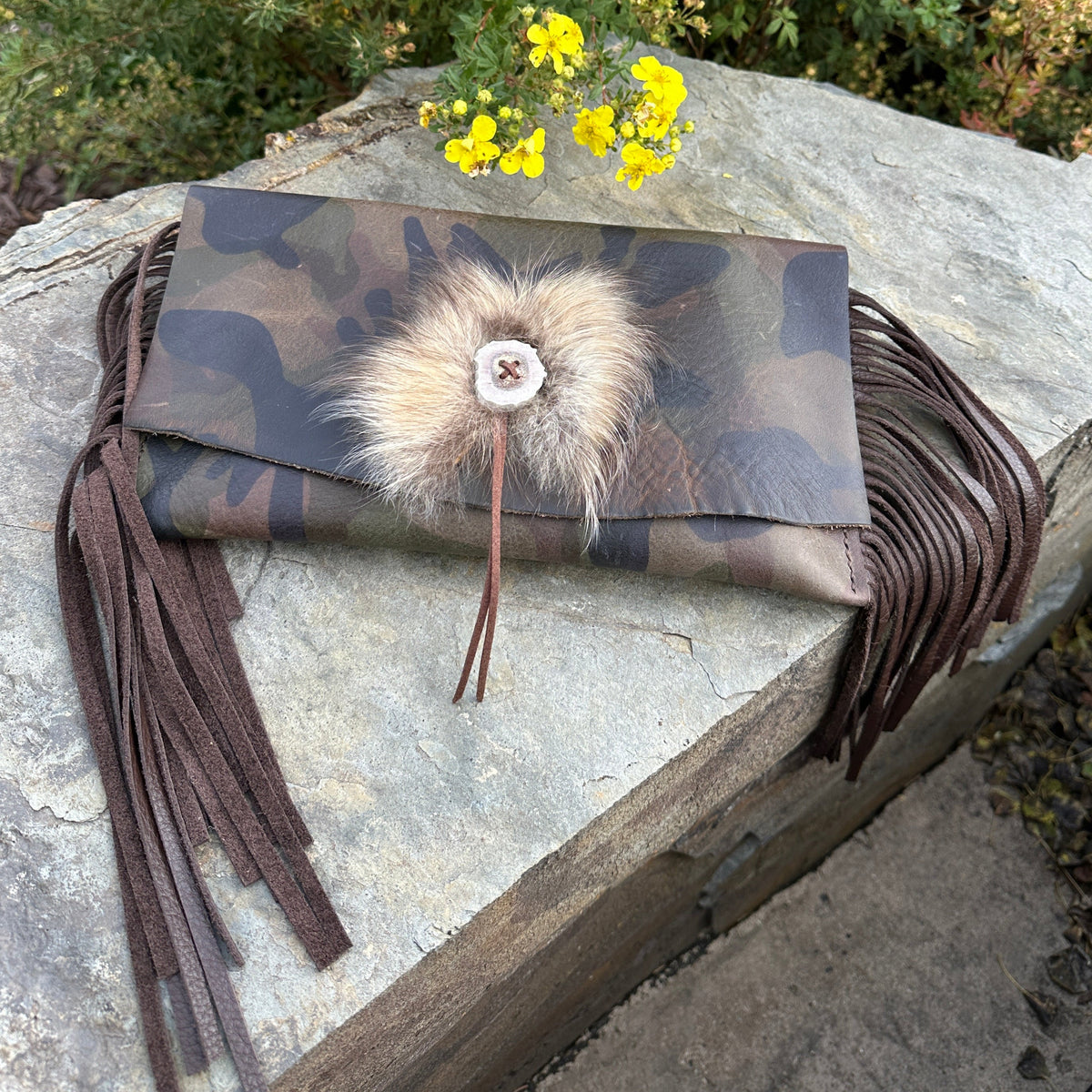 Upland Camo Leather Clutch by Bridger Leather — camo-printed Italian leather fold-over clutch with leather fringe, an antler button, and a Finn raccoon fur accent, handmade in Bozeman, Montana