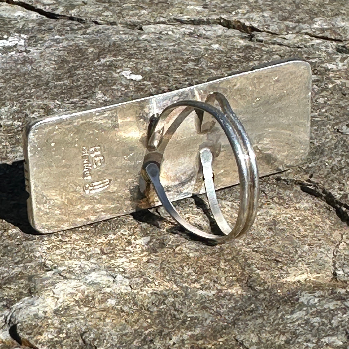 Back of the sterling silver ring showing the BE feather hallmark, STERLING stamp and split shank band