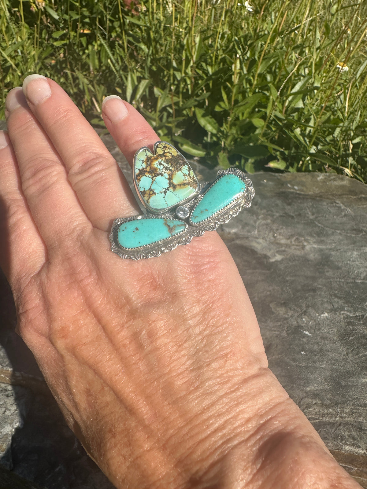 Spiderweb turquoise cowgirl hat ring worn on the hand, showing its statement size