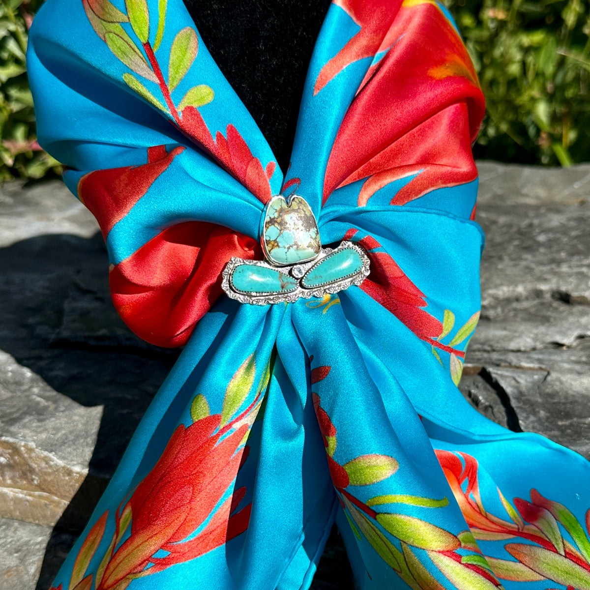 Spiderweb turquoise cowgirl hat ring worn as a scarf slide on the Indian Paintbrush silk scarf in turquoise blue and red