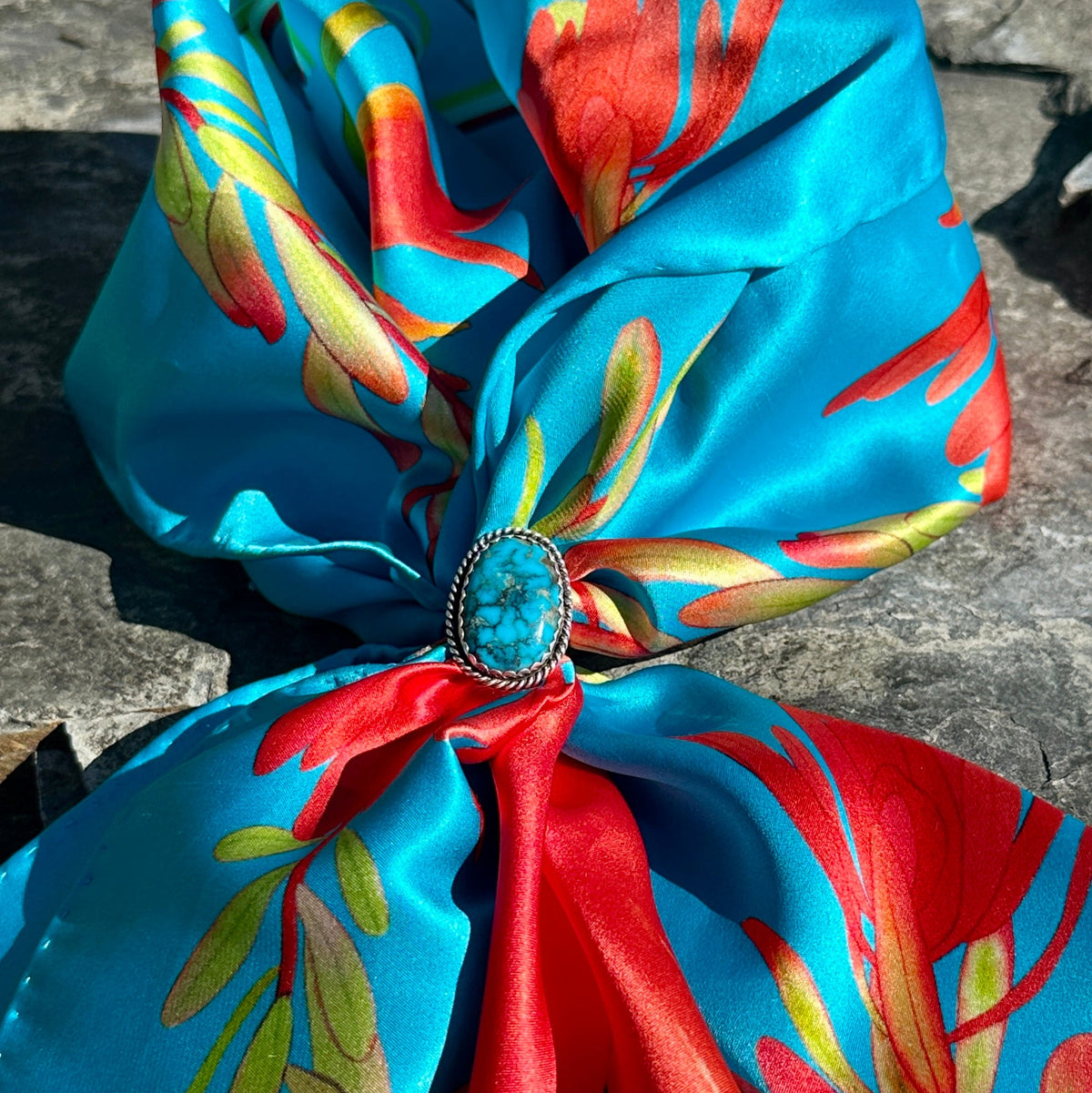 Sterling silver and blue turquoise ring worn as a scarf slide on the turquoise blue Indian Paintbrush silk scarf with red blooms