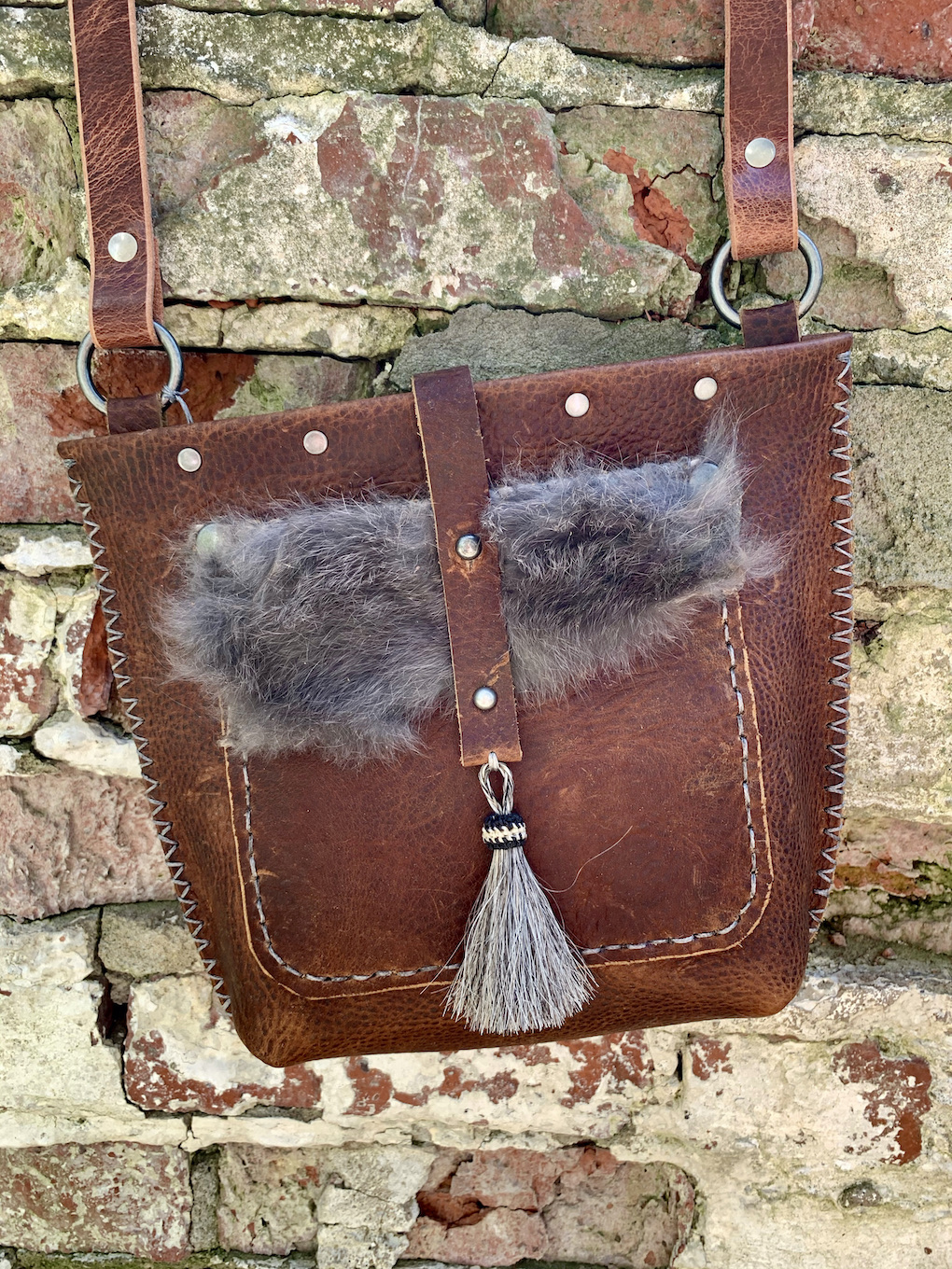 Bison leather bag trimmed with gray rabbit fur pocket and horse hair tassel