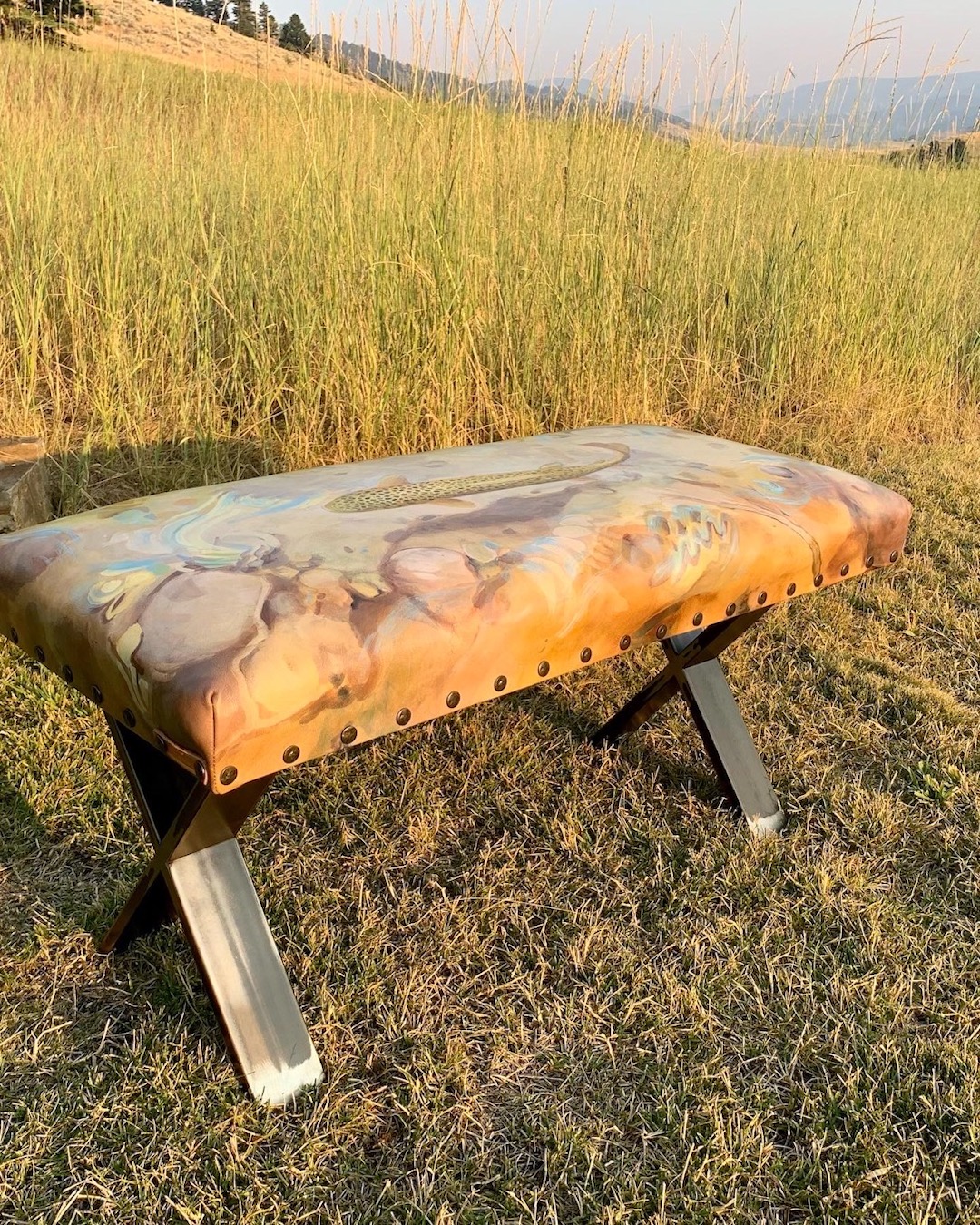 One of a kind leather bench with hand painted image of a brown trout swimming.